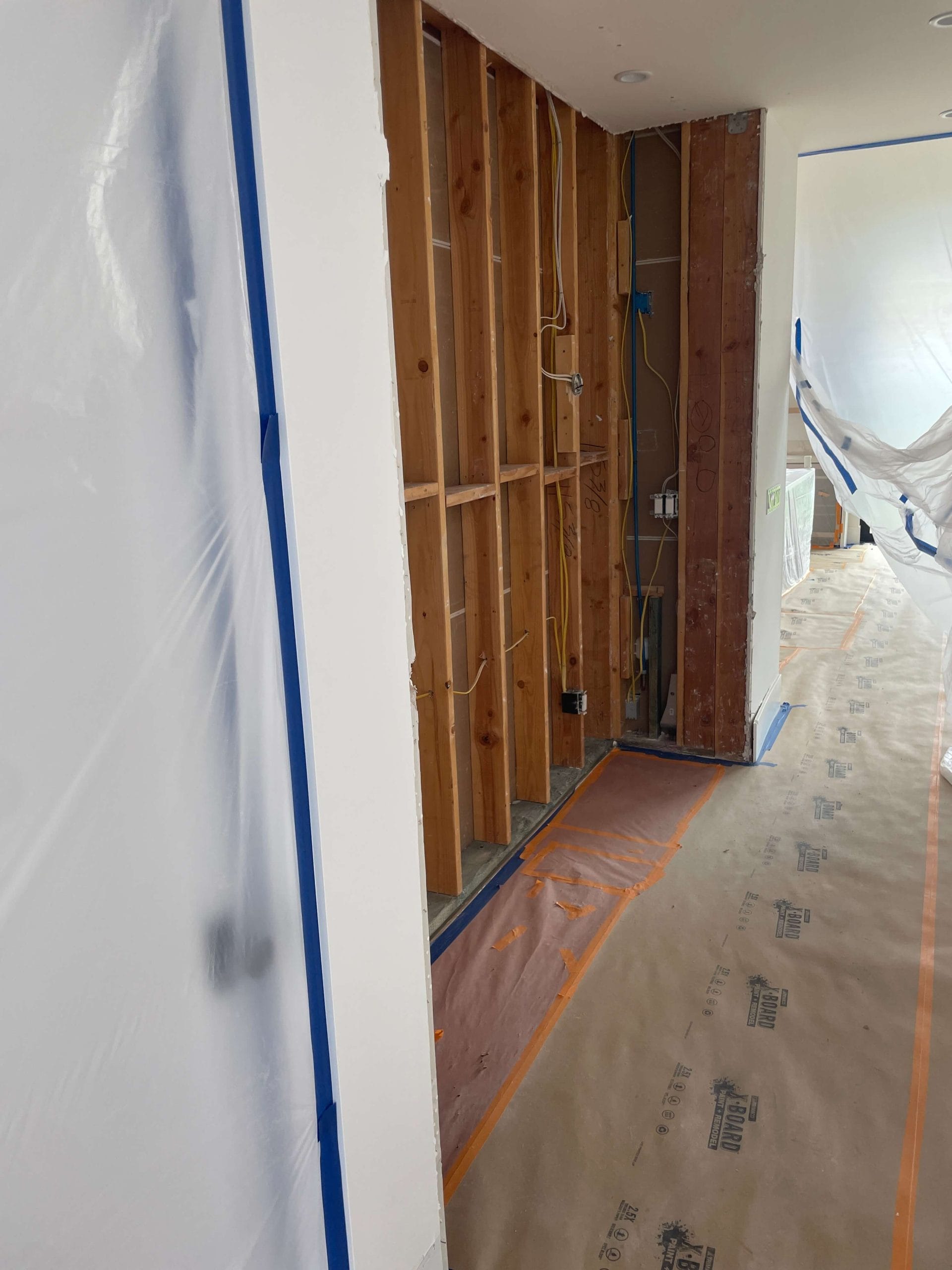 Wine cellar construction framing with exposed studs and electrical rough-in for custom installation