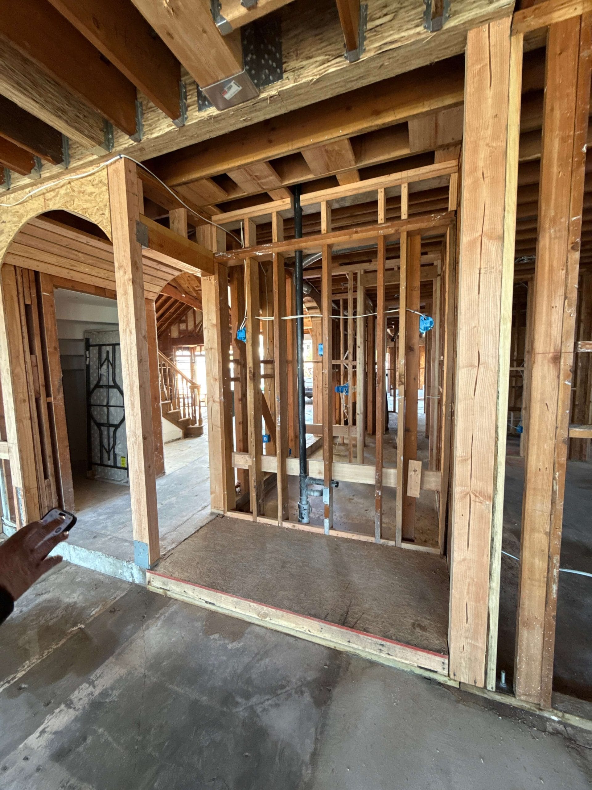 Custom wine cellar framing with arched entry and rough plumbing installation