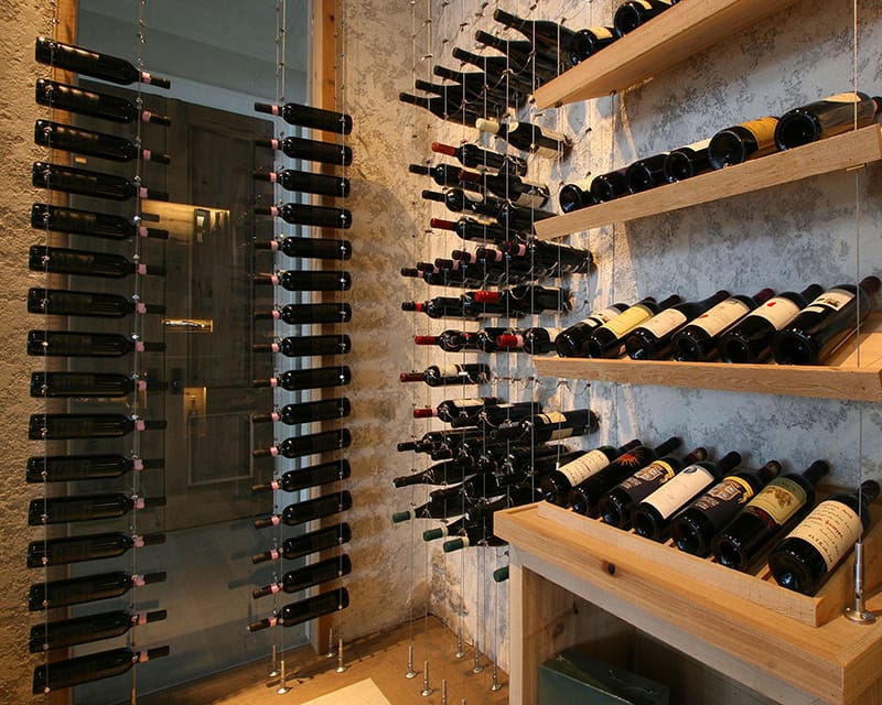 Modern custom wine cellar with wall-mounted racking and climate-controlled glass enclosure