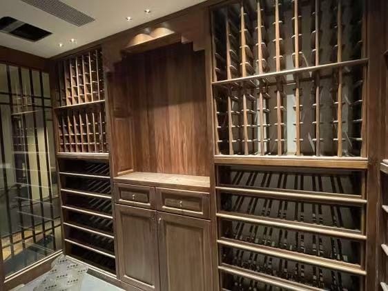Luxury wine cellar with custom wood racking, cabinetry, and integrated bottle storage.